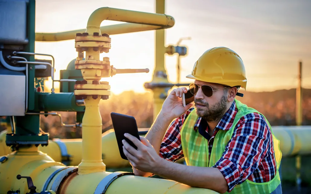 Man in oilfield with tablet using Enbrec oil and gas ticketing software