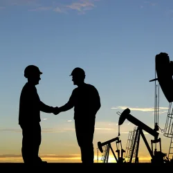 oil and gas field workers shaking hands